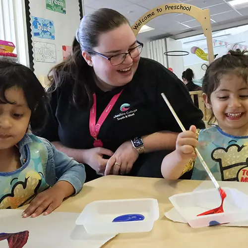 Early Years student teaching painting to children