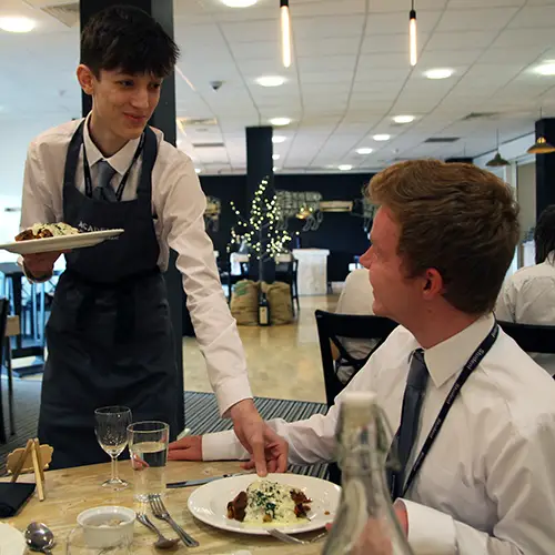 Hospitality student serving a customer