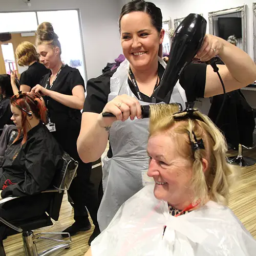 Hairdressing student finishing a hair style