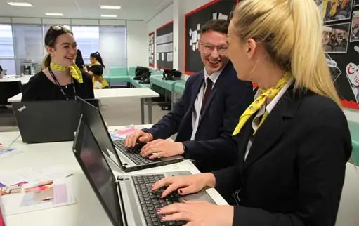 T levels page image girl and boy laugh at computer