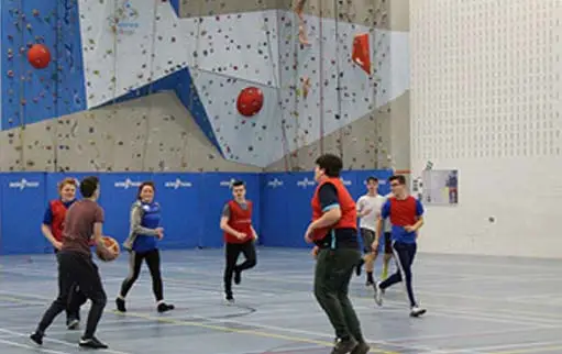 Group of students playing football in the gym