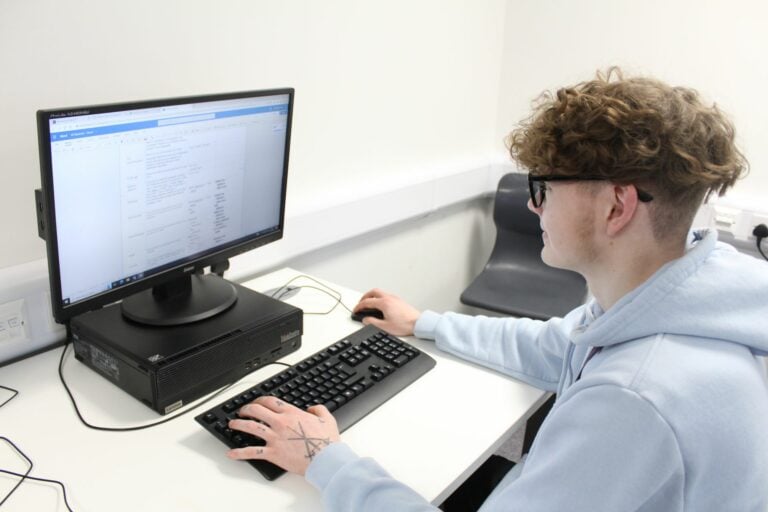 computing student at desk with computer